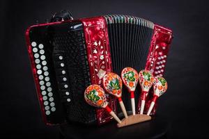 Instrumentos folclóricos rusos bayan rojo sobre un fondo negro acordeón ruso. foto