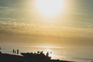 Silhouettes of people at sunset on the background of the sea photo