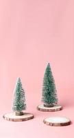 Tree Christmas tree on wood log slice on pastel pink photo