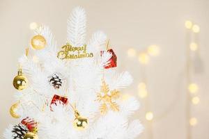 Decoración del árbol de Navidad blanco con copo de nieve dorado y cono de pino de bola en bokeh foto