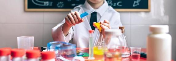 Little boy playing with chemical liquids photo