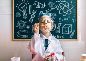 Niño haciendo pompas de jabón contra la pizarra dibujada foto