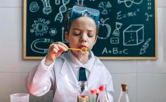 Boy playing with chemistry game blowing bubbles photo