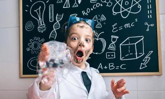 Happy little boy holding glass with soap foam photo