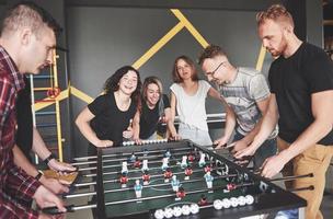 Friends together play board games, table football, have fun free time. photo