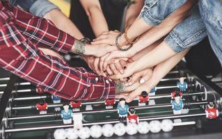 Smiling young people playing table football while on vacation photo