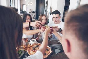 Friends got together by table with delicious food with glasses of red wine to celebrate a special occasion photo