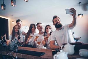 Leisure and communication concept. Group of happy smiling friends enjoying drinks and talking at bar or pub photo