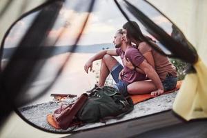 View from tent of couple lying a view of lake during hiking trip. avel Lifestyle concept adventure vacations outdoor photo