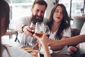 Friends got together by table with delicious food with glasses of red wine to celebrate a special occasion photo