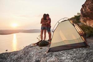 foto de feliz cerca de la tienda con vistas al lago durante el viaje de senderismo. concepto de vacaciones de aventura de estilo de vida de viaje