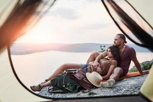 View from tent of couple lying a view of lake during hiking trip. avel Lifestyle concept adventure vacations outdoor photo