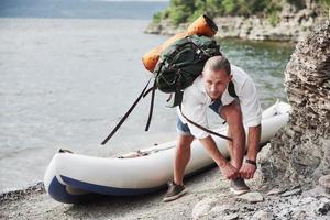 A young man is traveling with a backpack using a boat. The way of life of travel and nature with nature photo