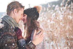 christmas happy couple in love embrace in snowy winter cold forest, copy space, new year party celebration, holiday and vacation, travel, love and relations