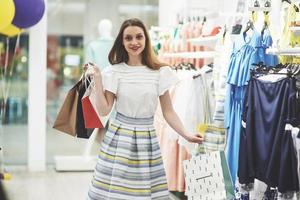 Happy woman with shopping bags goes to the store. The favorite occupation for all women, lifestyle concept photo