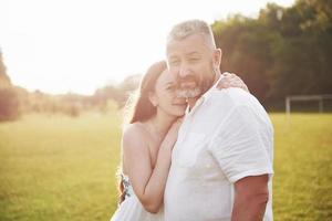 An elderly man hugged his adult daughter outdoors photo