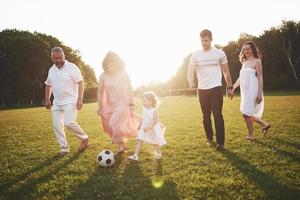 Cheerful active family having fun at countryside in summer day. photo