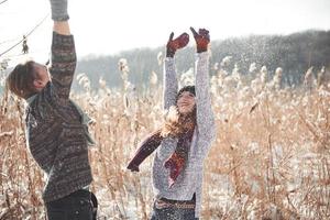 concepto de personas, temporada, amor y ocio - pareja feliz divirtiéndose sobre fondo de invierno foto