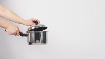 Pot cleaning. Man hand on white background cleaning the non stick pot photo