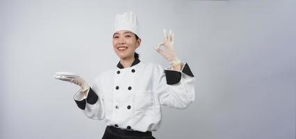 Asian woman chef holding smartphone or digital tablet and received order from online photo