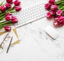 Workspace with keyboard and tulips photo