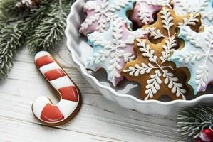 Bowl of gingerbread Christmas cookies on rustic white wooden table photo