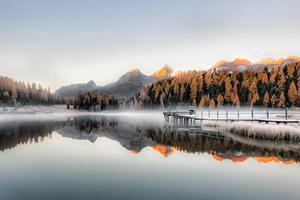 pequeño lago alpino con niebla del amanecer foto
