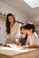 Family happy moments when children Helping mom cook food in the kitchen. photo