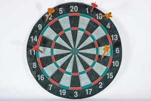 old shabby dartboard with darts on white background