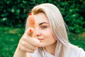 Woman smiling, making shot of fingers in camera photo