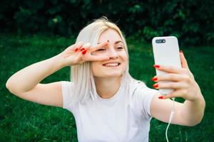 Woman in headphones and smartphone in hands on green background photo
