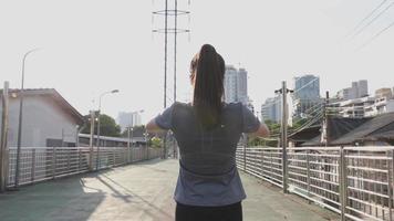 mulher asiática alongamento antes de correr na rua. video