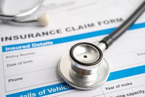 Stethoscope on Insurance  claim accident car form, Car loan, insurance and leasing time concepts. photo