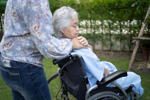 médico ayuda y cuidado paciente asiático mayor o anciano mujer sentada en silla de ruedas en el parque en la sala del hospital de enfermería, concepto médico fuerte y saludable. foto