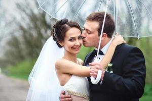 la novia y el novio en un día lluvioso de boda caminando