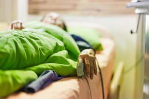 Elderly woman patient lying bed wearing fingertip pulse oximeter in operating theatre. photo