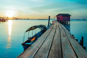 Wooden bridge with hut at sunrise in Chew jetty Georgetown Penang Malaysia. photo