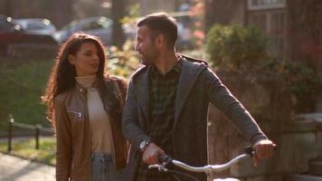 Handsome young couple walking with bicycle in autumn park video