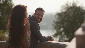 Pretty young couple standing on the outdoor balcony on sunny autumn day video