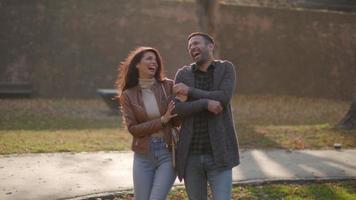 casal jovem bonito caminhando no parque de outono video