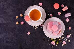 Beautiful pink tasty macaroons on a concrete background photo