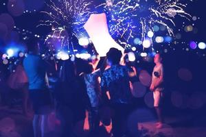la gente celebra el año nuevo. Desenfoque de círculo de fuegos artificiales. colorido en celebración. playa de tailandia foto