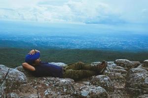 hombre asiáticos viajan relajarse en las vacaciones. Ver la naturaleza de la montaña en los acantilados. foto