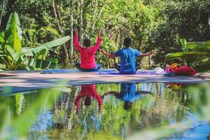 Asian woman and Asian man travel nature. Travel relax. Yoga posture concept, Good health care with yoga postures. Outdoor exercise Relax yoga.