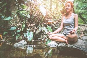 mujer asia viajeros viajes naturaleza bosques cascada. meditar en yoga