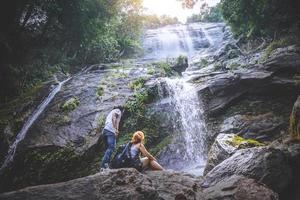 viajes masculinos y femeninos. parejas masculinas y femeninas viajeros asiáticos viajan naturaleza bosques, montañas, cascadas foto