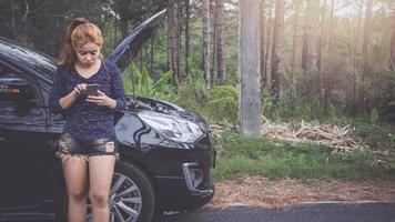 Las mujeres usan el teléfono para contactar con un auto roto. foto