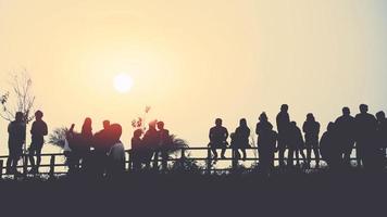 asians travel relax in the holiday.People stand looking at the sun in the morning. Stand up for sunrise on the Moutain photo