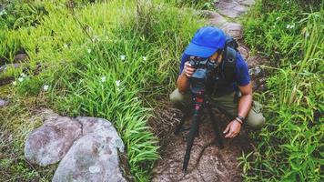 fotógrafo hombre asiático. fotografía de viaje de la naturaleza. viaje relajarse en el paseo de vacaciones en el bosque. foto