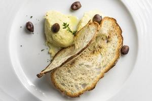 Plate of Ligurian-style cod fish with crispy bread and olives photo